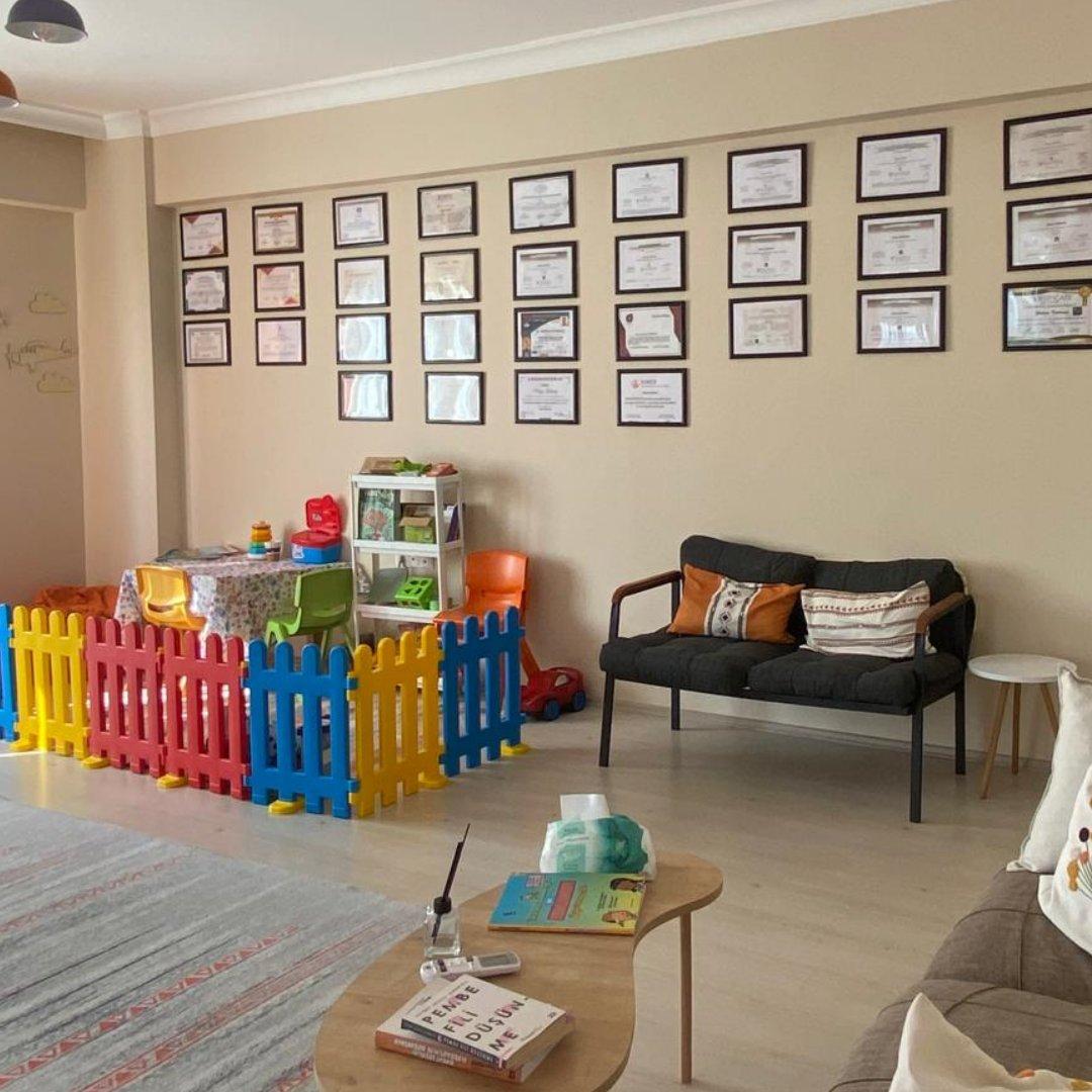 Prusa Psikoloji bekleme alanı: sertifika duvarı, koltuklar, sehpa ve çocuk oyun alanı